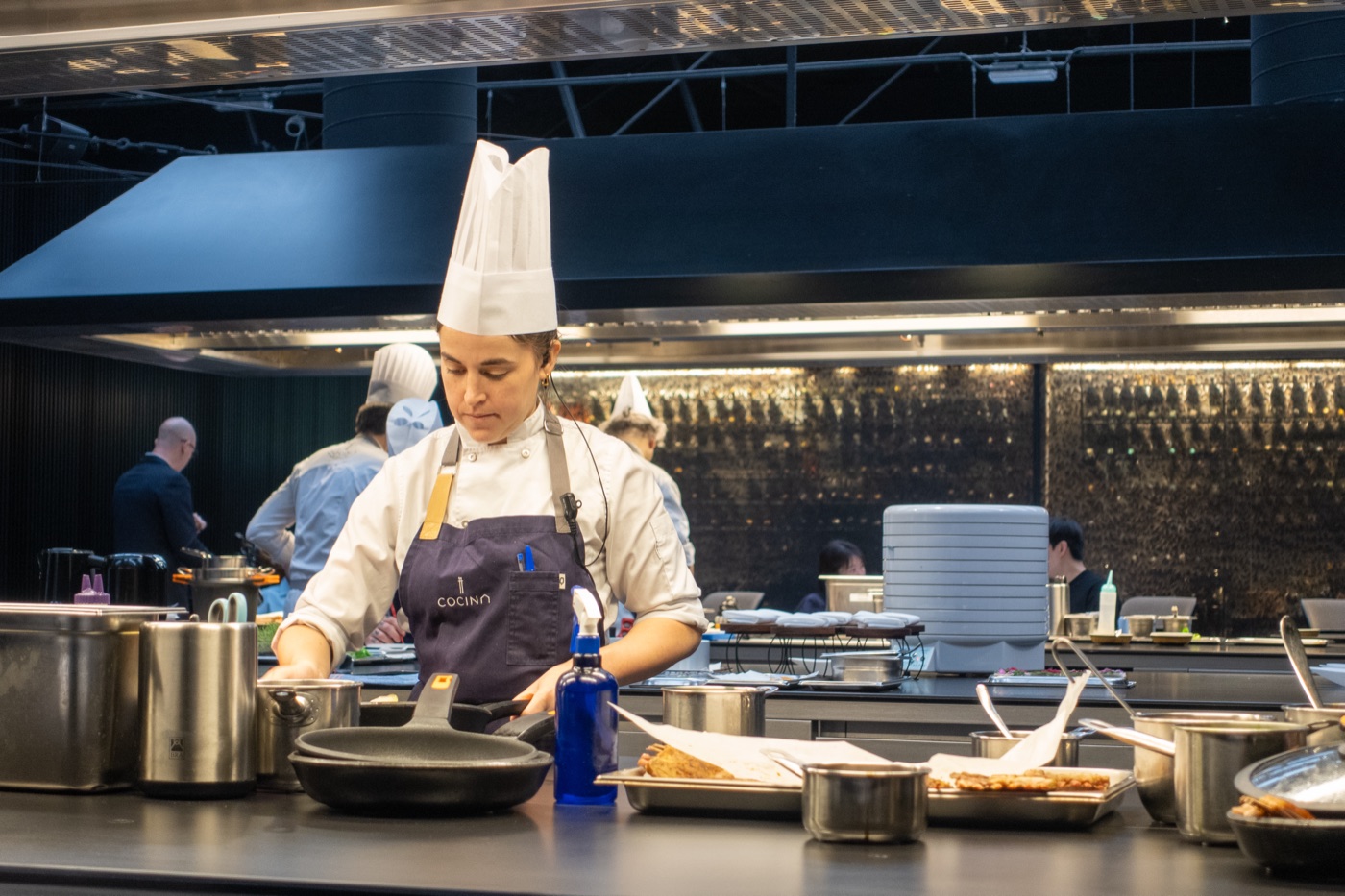 A cook at the stove in the open kitchen.