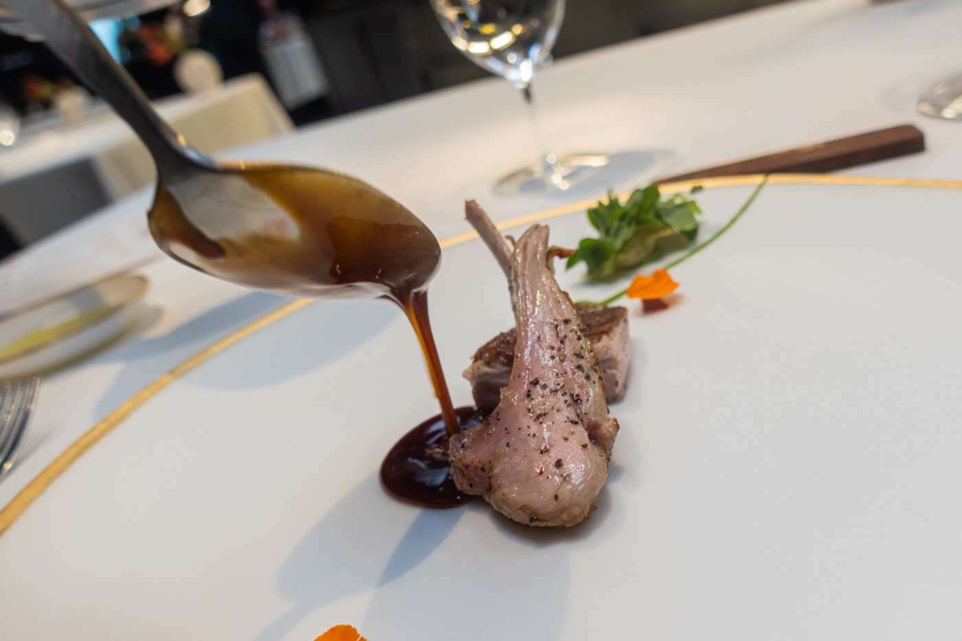 Aged suckling lamb with herbs, Padrón peppers, soufflé potatoes and ají. Spring. The sauce is spooned at the table.